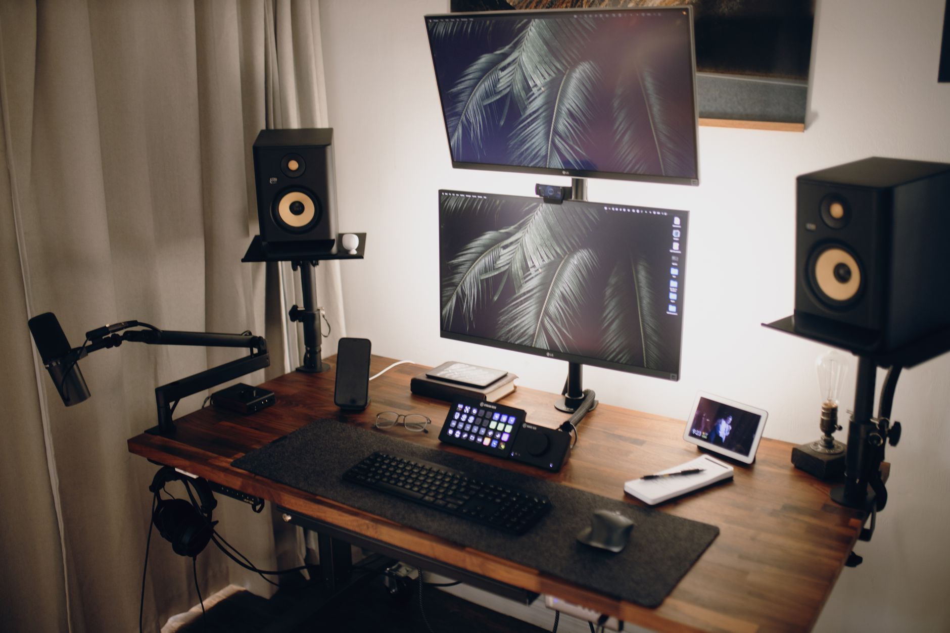 Wood top standing desk with two gaming monitors and keyboard tray
