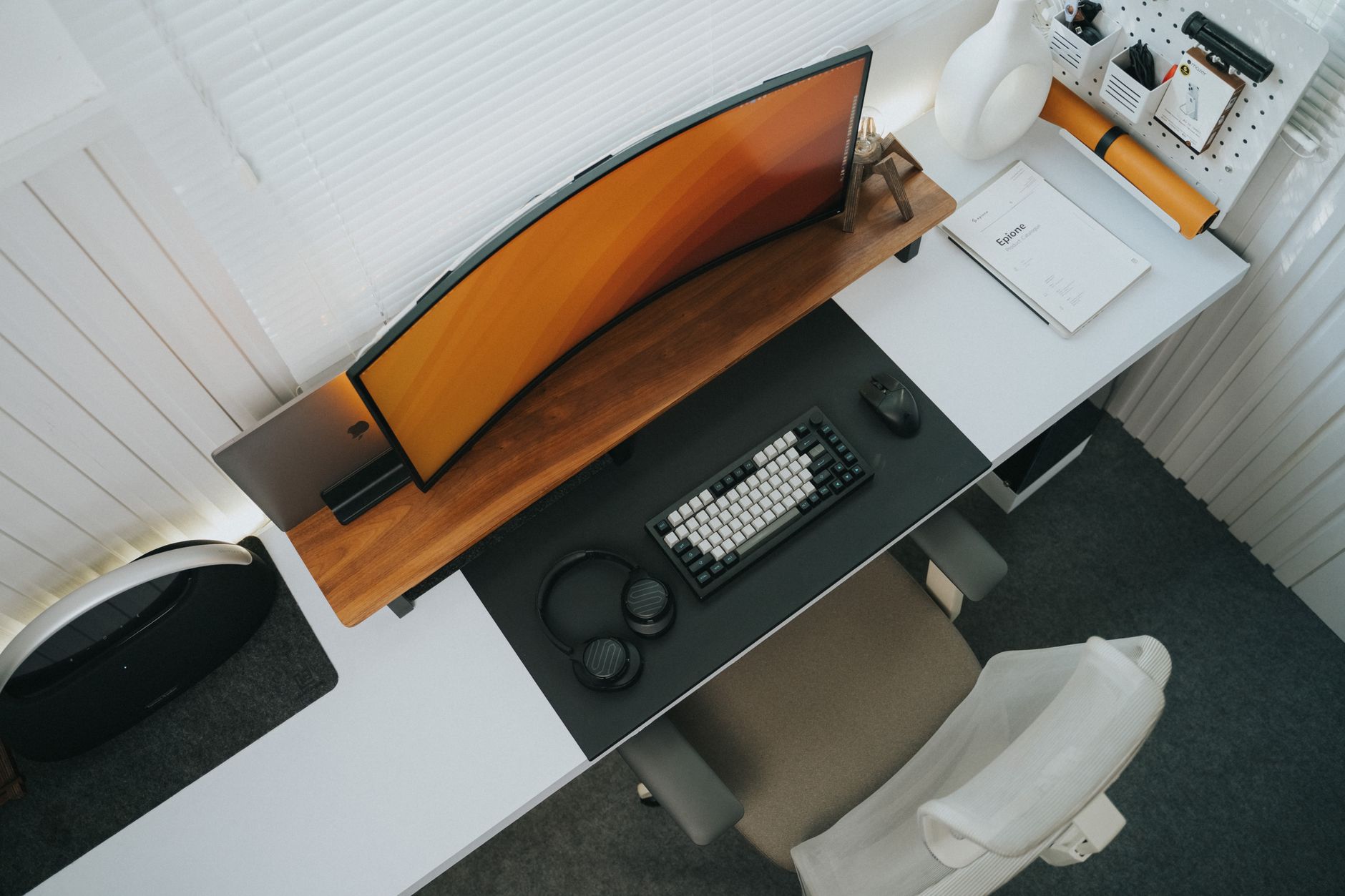 Raised sit stand desk converter holding a monitor and keyboard on a wooden desk