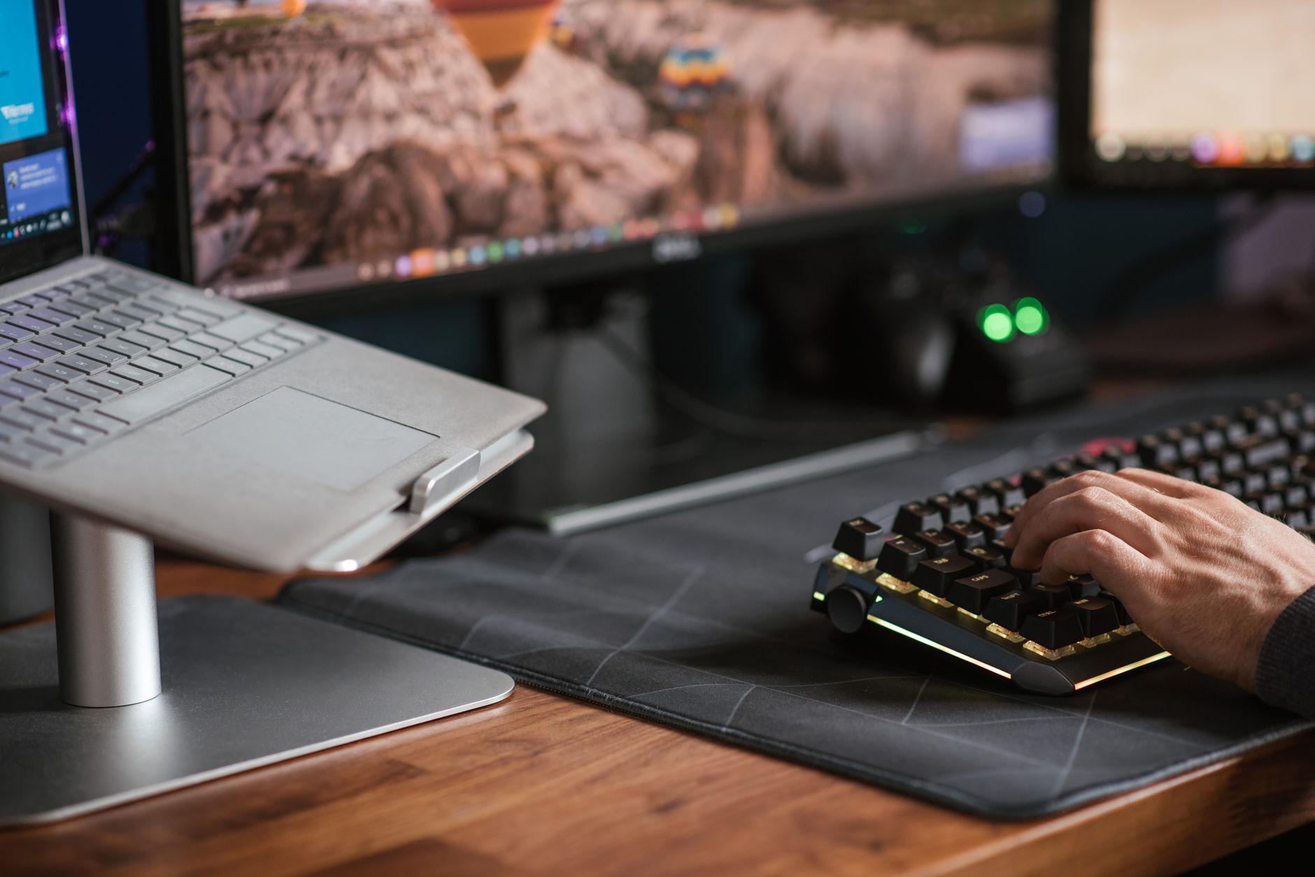 Folded aluminum laptop stand sitting on a wooden desk beside a laptop