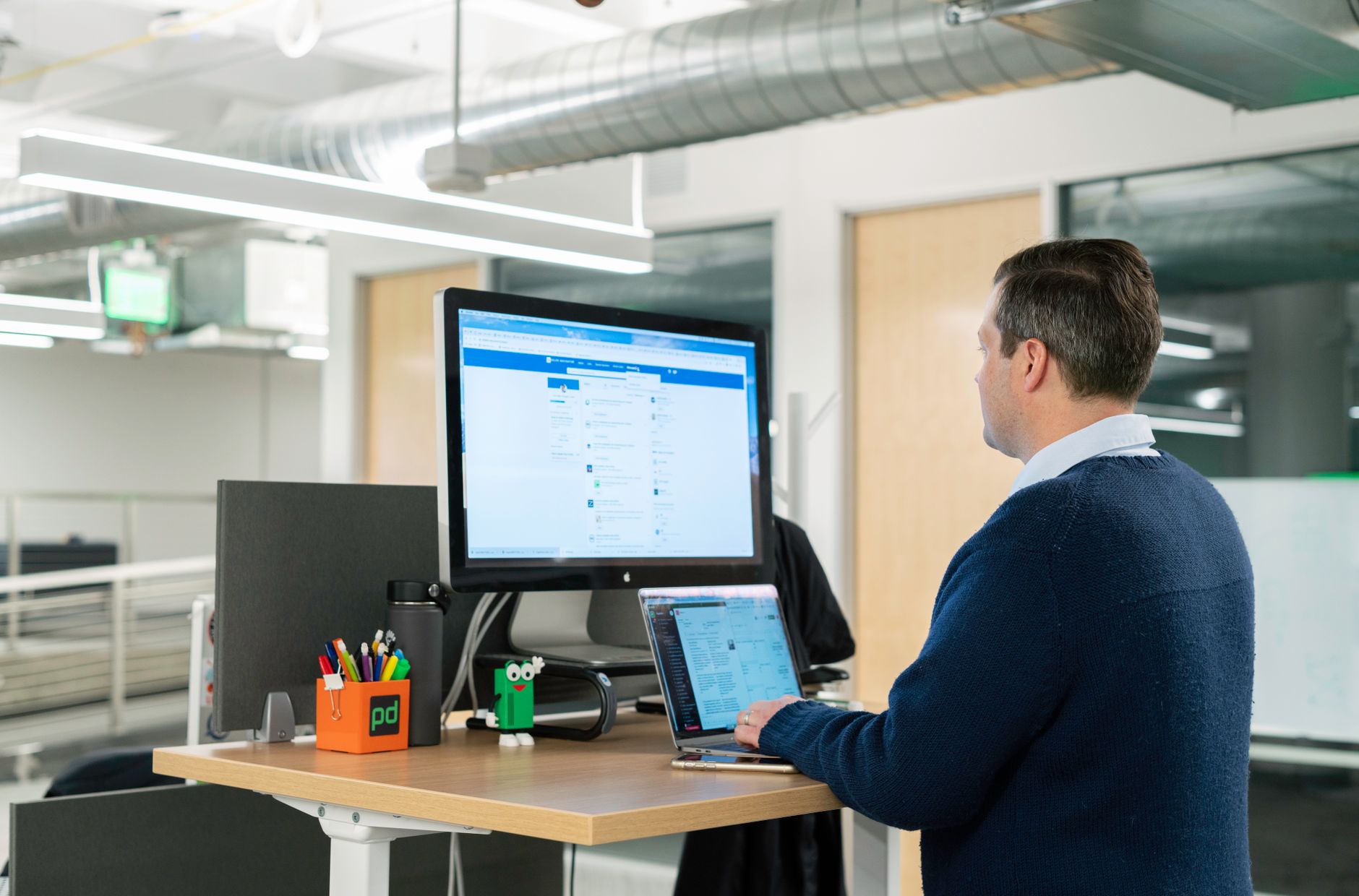 a person stretching their wrists while working at a standing desk